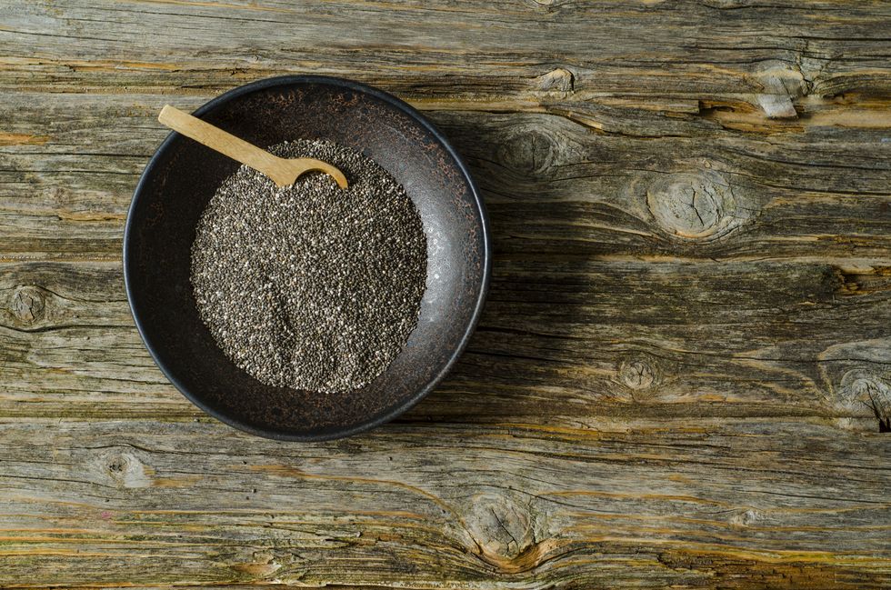 Chia seeds with a wooden spoon in a bowl
