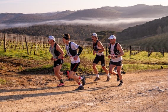 group of runners participating in a trail run through a vineyard landscape