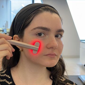 a woman holding a solawave to her face