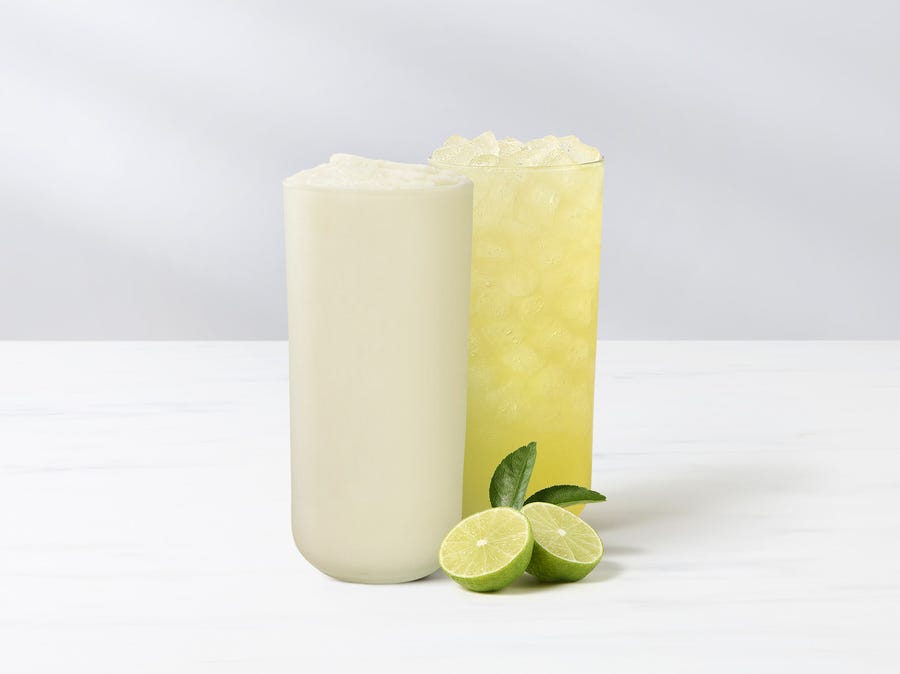 two refreshing beverages with lime slices one creamy and the other icy