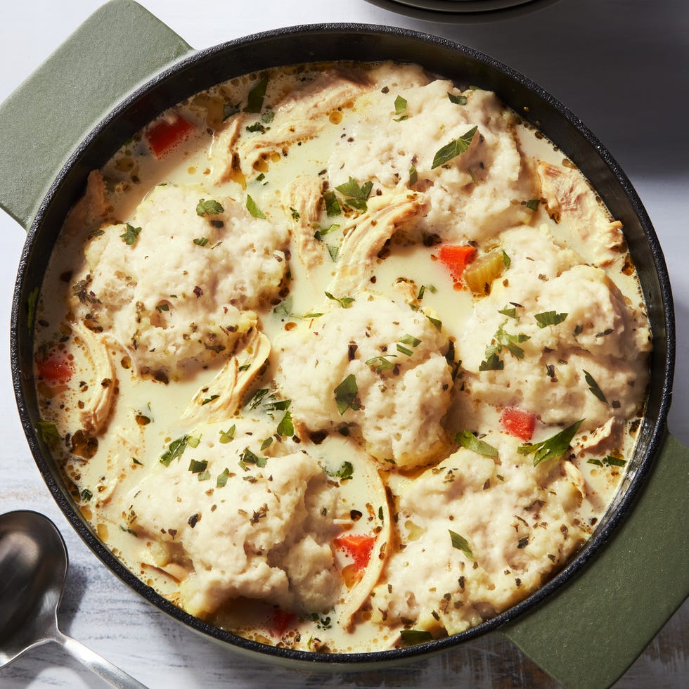 shredded chicken and dumplings and carrots in a creamy broth, topped with chopped parsley