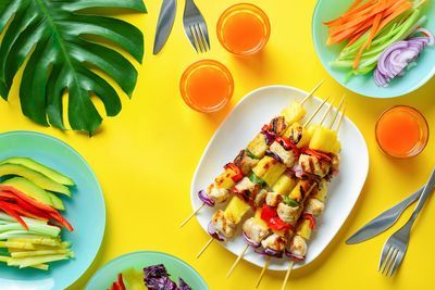 https://hips.hearstapps.com/hmg-prod/images/chicken-and-pineapple-kebabs-on-a-white-plate-and-yellow-background-1587574166.jpg