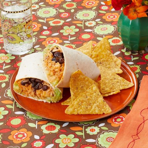 ncho chicken burritos on brown red plate with tortilla chips and floral background