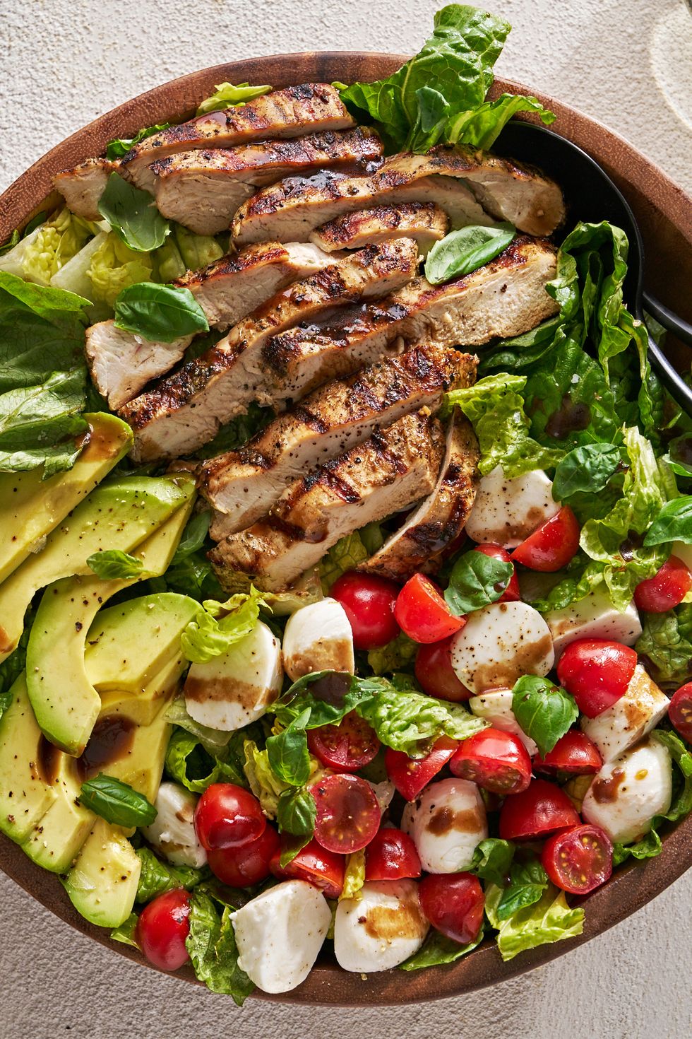 chicken avocado caprese salad in a bowl with balsamic dressing