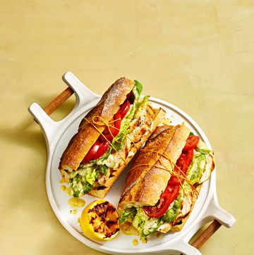 chicken caesar sandwich with tomato and lettuce on a baguette