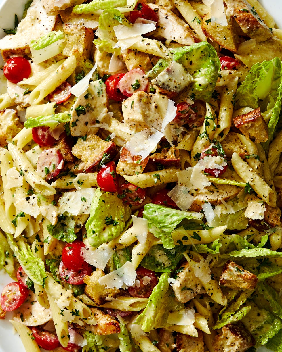chicken caesar pasta salad with chicken, tomatoes, penne pasta, and parmesan all tossed in creamy caesar dressing