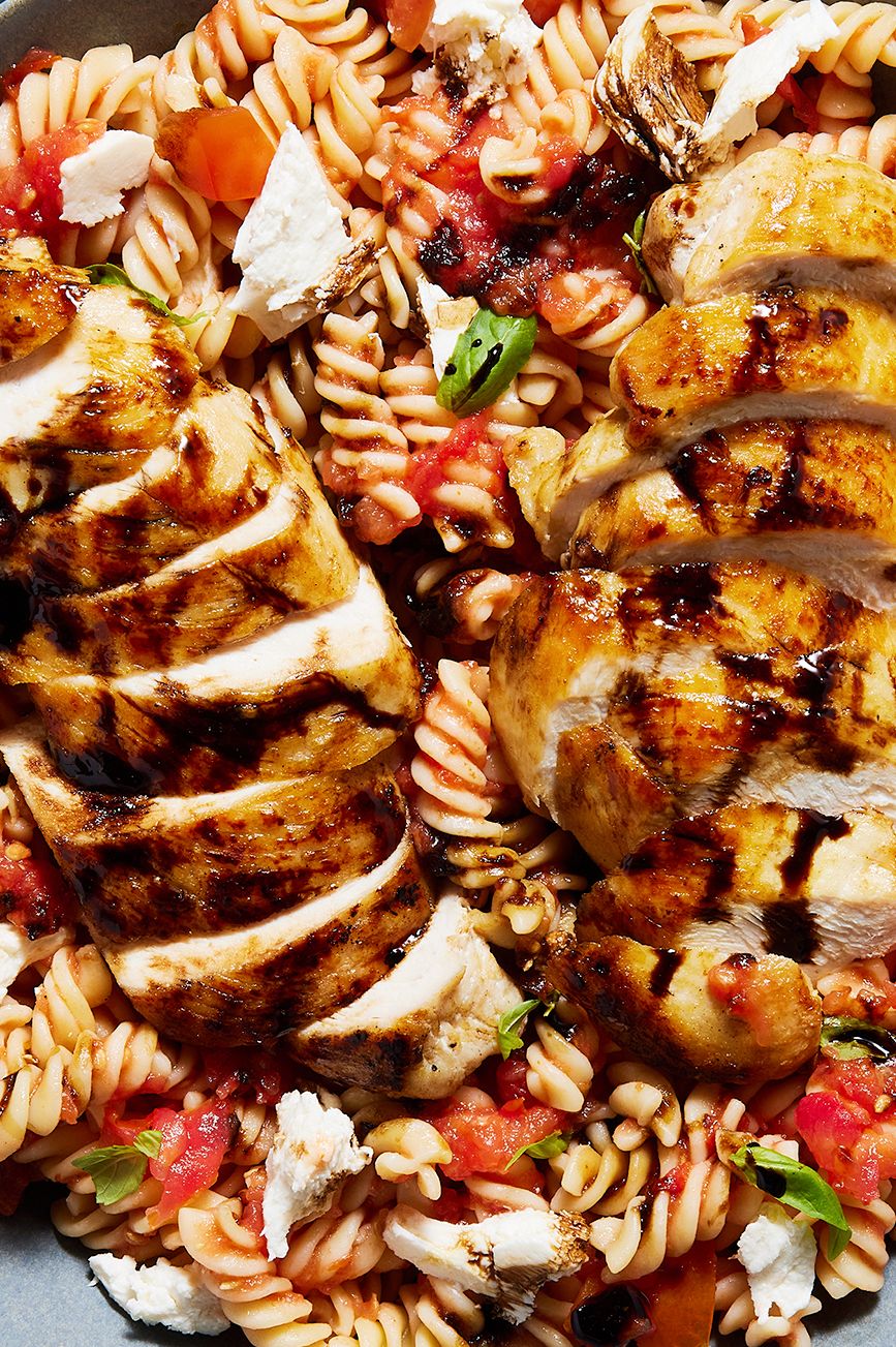 chicken breasts on top of a caprese pasta salad
