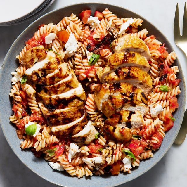 chicken breasts on top of a caprese pasta salad