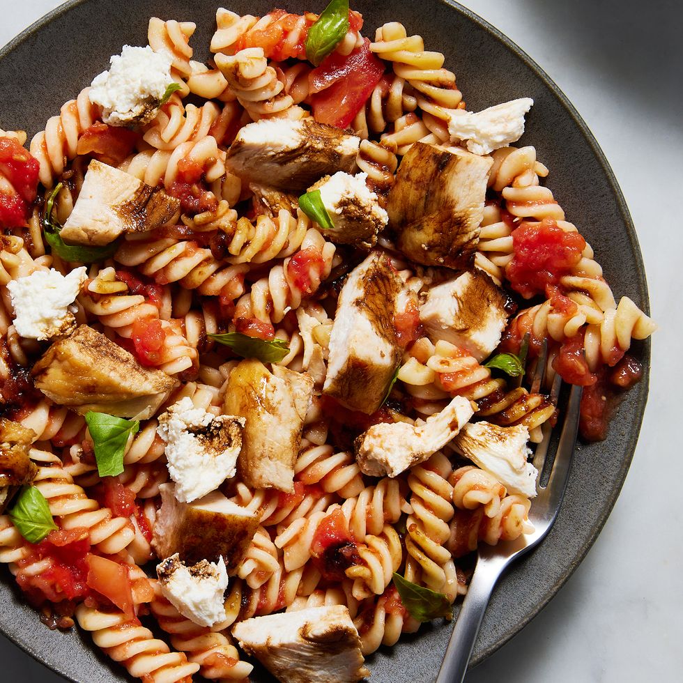 chicken breasts on top of a caprese pasta salad