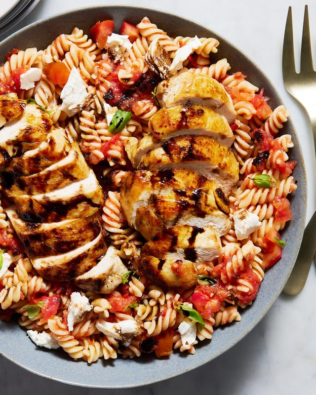 chicken breasts on top of a caprese pasta salad
