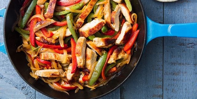 a skillet of with chicken fajitas filled with peppers and onions