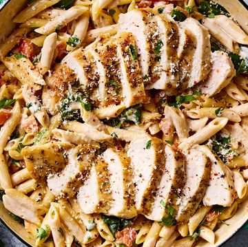 pasta in a pot topped with chicken slices and herbs
