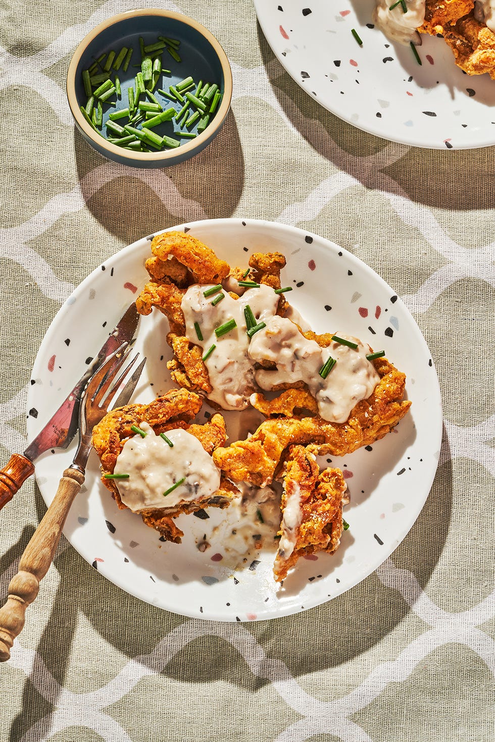 chicken fried mushrooms and gravy on a white speckled plate