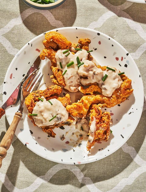 chicken fried mushrooms and gravy on a white speckled plate