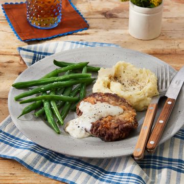 chicken fried steak on a plate with green beans and mashed potatoes