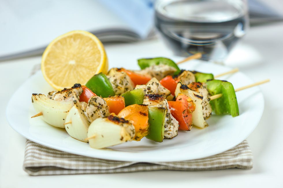 chicken kebab with vegetables and lemon with glass of water