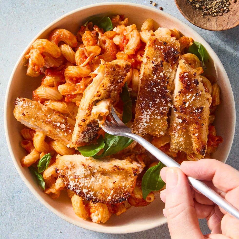 red sauce pasta topped with cheese and sliced chicken breast