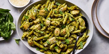 chicken pesto pasta topped with basil and parmesan cheese