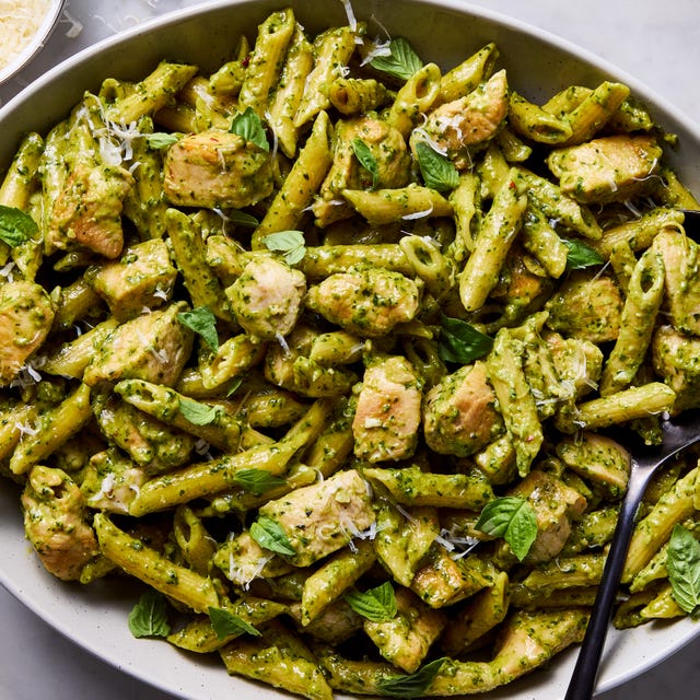 chicken pesto pasta topped with basil and parmesan cheese