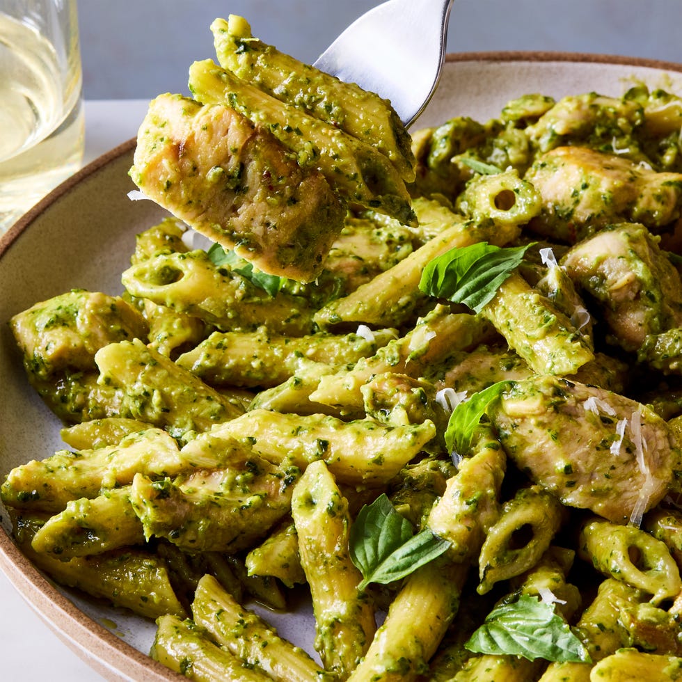 chicken pesto pasta topped with basil and parmesan cheese