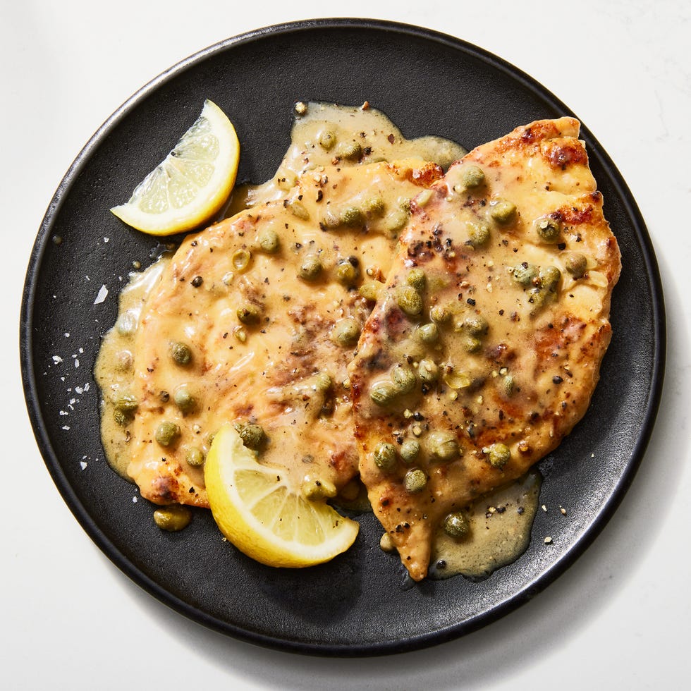 chicken piccata in a skillet with lemon butter caper sauce