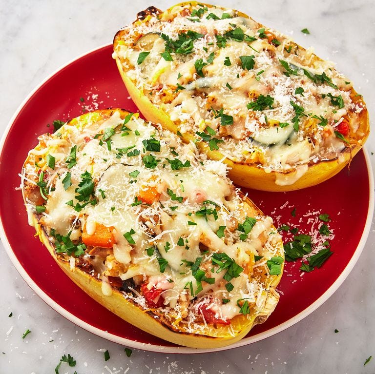 chicken primavera spaghetti squash halves on a red plate