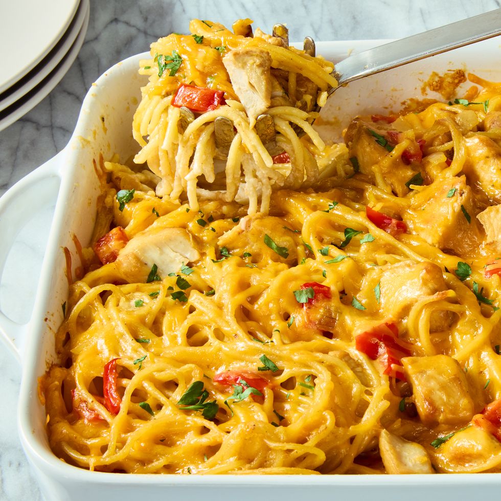 chicken, spaghetti, and red peppers covered in cheese in a casserole