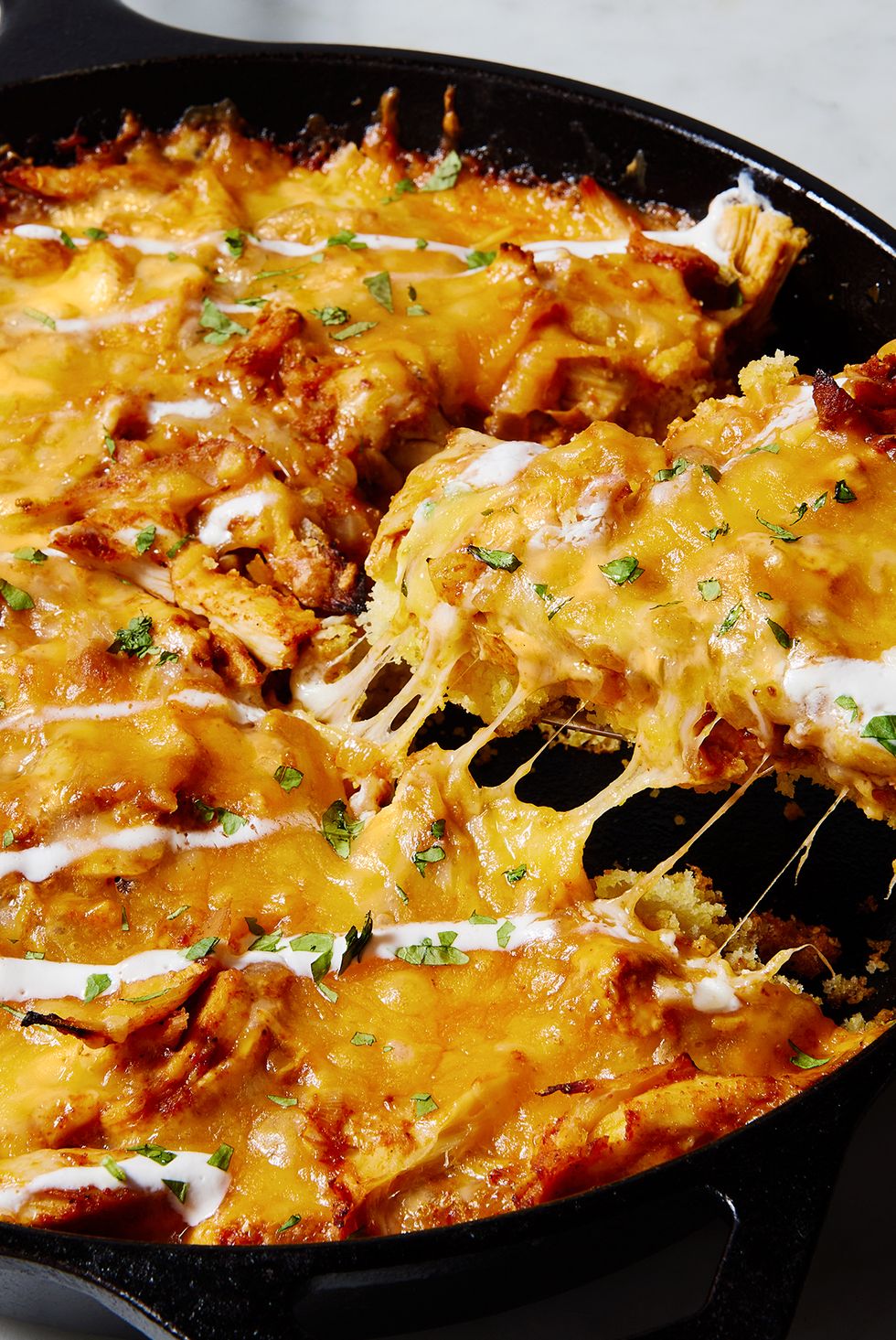 chicken tamale pie in a skillet with sour cream