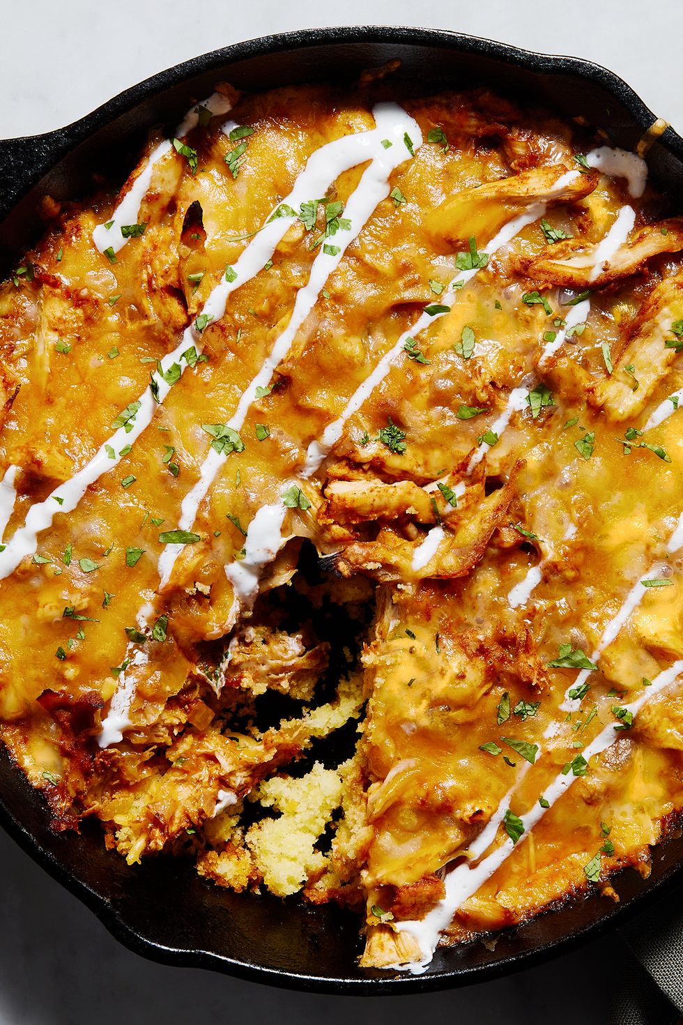 chicken tamale pie in a skillet with sour cream