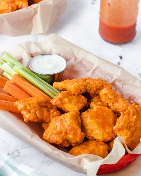 air fryer boneless chicken wings in red basket with carrot sticks