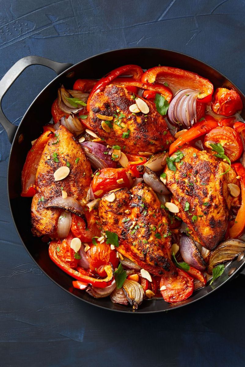 chicken with stewed peppers and tomatoes in a skillet