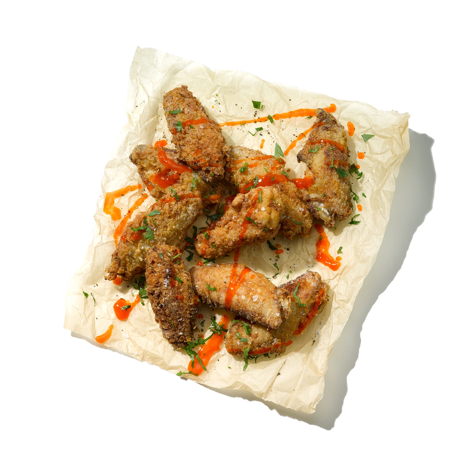 fried chicken wings arranged with sauce and herbs