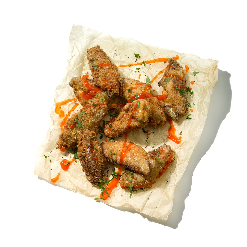 fried chicken wings arranged with sauce and herbs