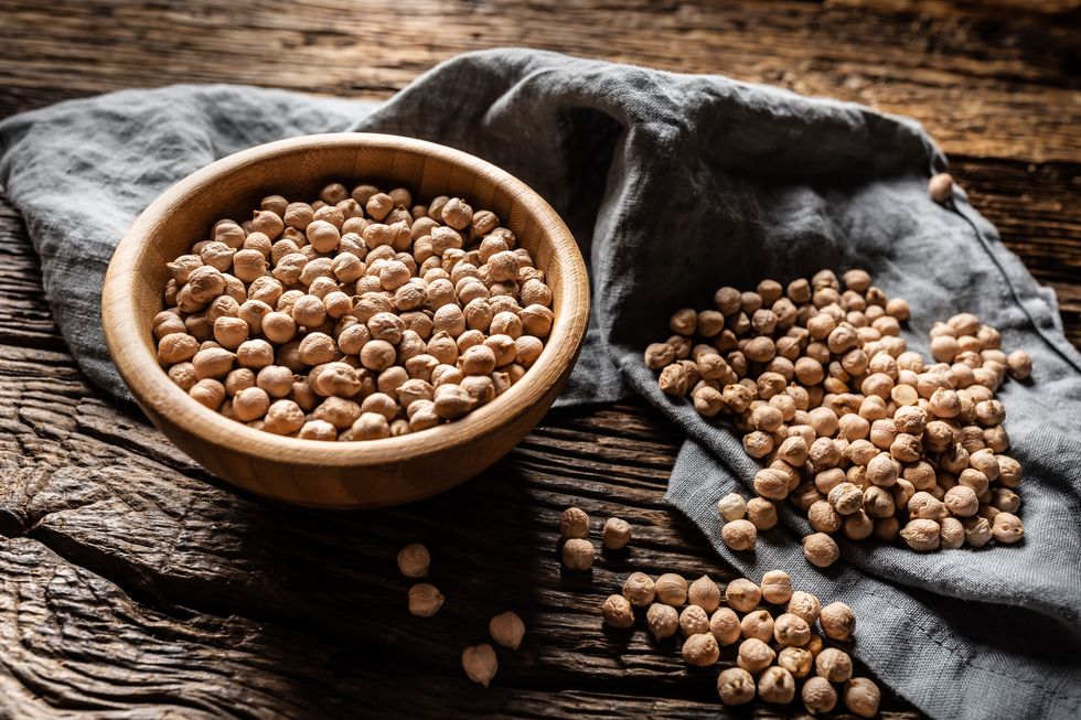 chickpea in a wooden bowl close up on an oak table