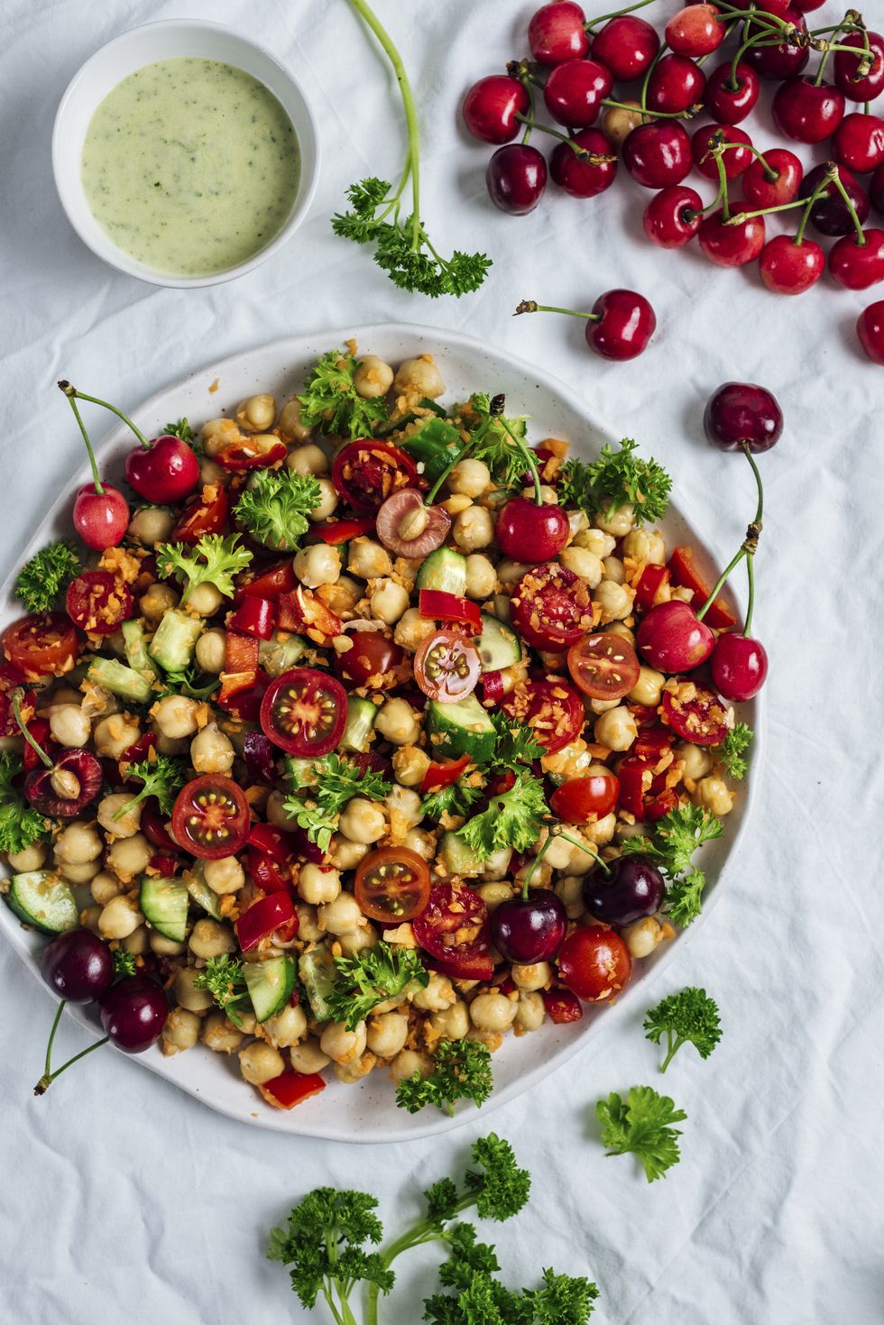Chickpea salad with shredded carrot,  cucumbers and cherries accompanied with a curry yogurt dressing.