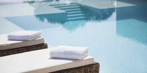 Folded towels on lounge chairs beside pool