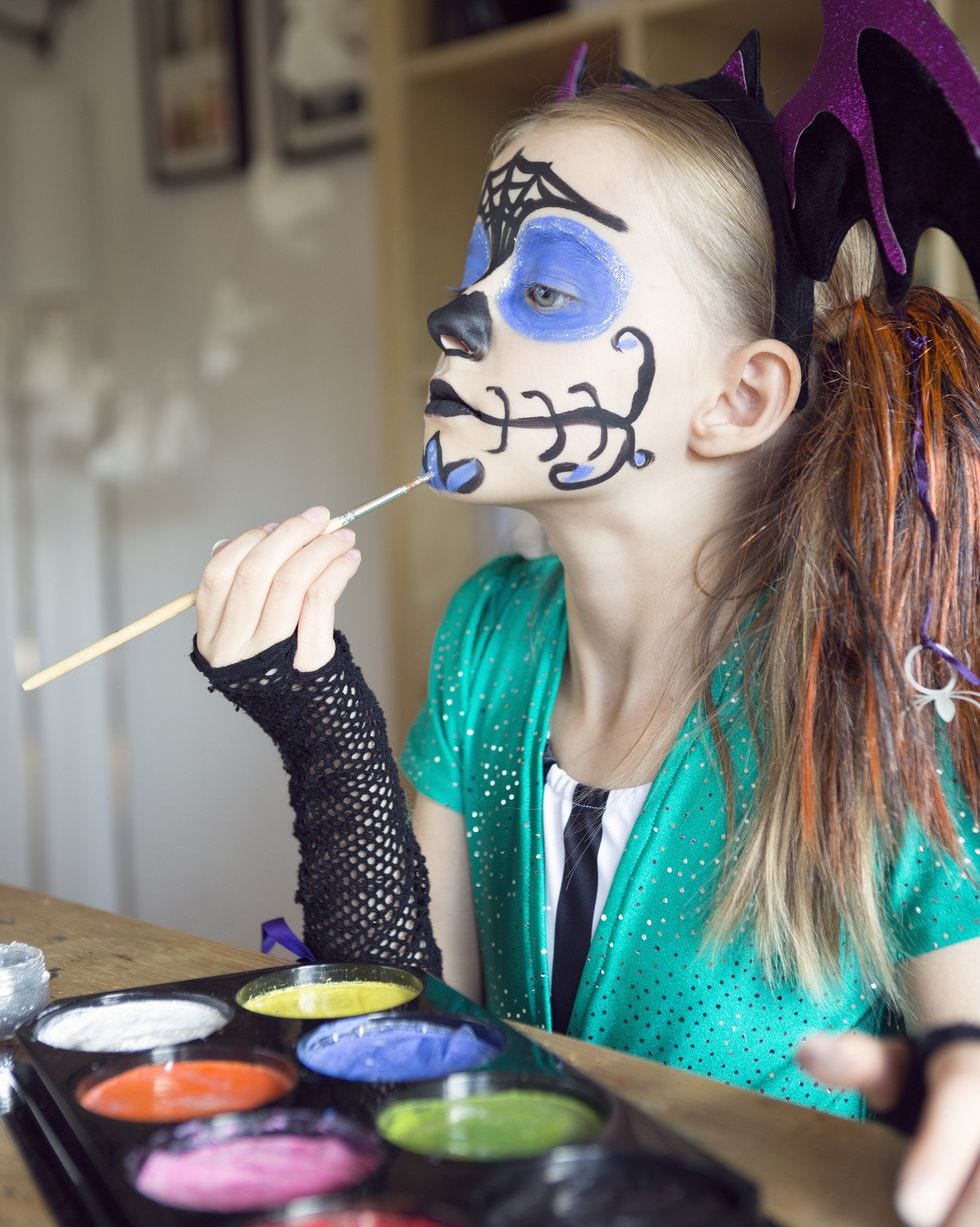 child applying halloween face paints
