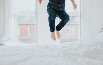 child bouncing on a bed