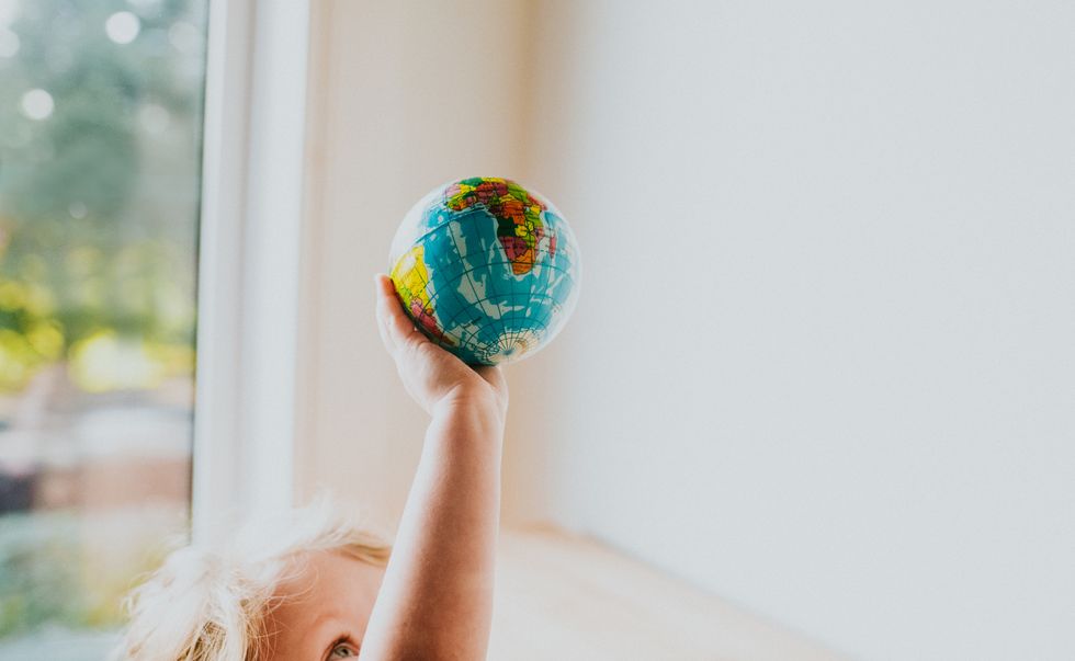 child holding globe ball