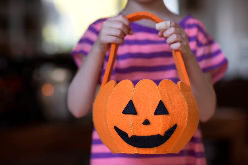 child 6 7 holding pumpkin shaped halloween bag