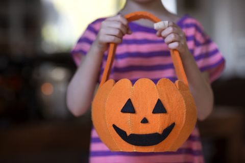 child 6 7 holding pumpkin shaped halloween bag
