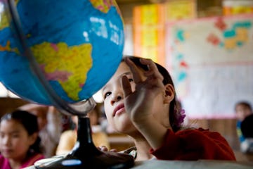 young asian girl looking at a globe