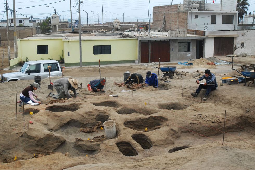 Archeoloog Gabriel Prieto tweede van links verlaat de site waar meer dan 500 jaar geleden een ritueel offer plaatsvond Hij traint lokale studenten om de volgende generatie wetenschappers te worden zodat de geschiedenis van Huanchaco gedocumenteerd wordt
