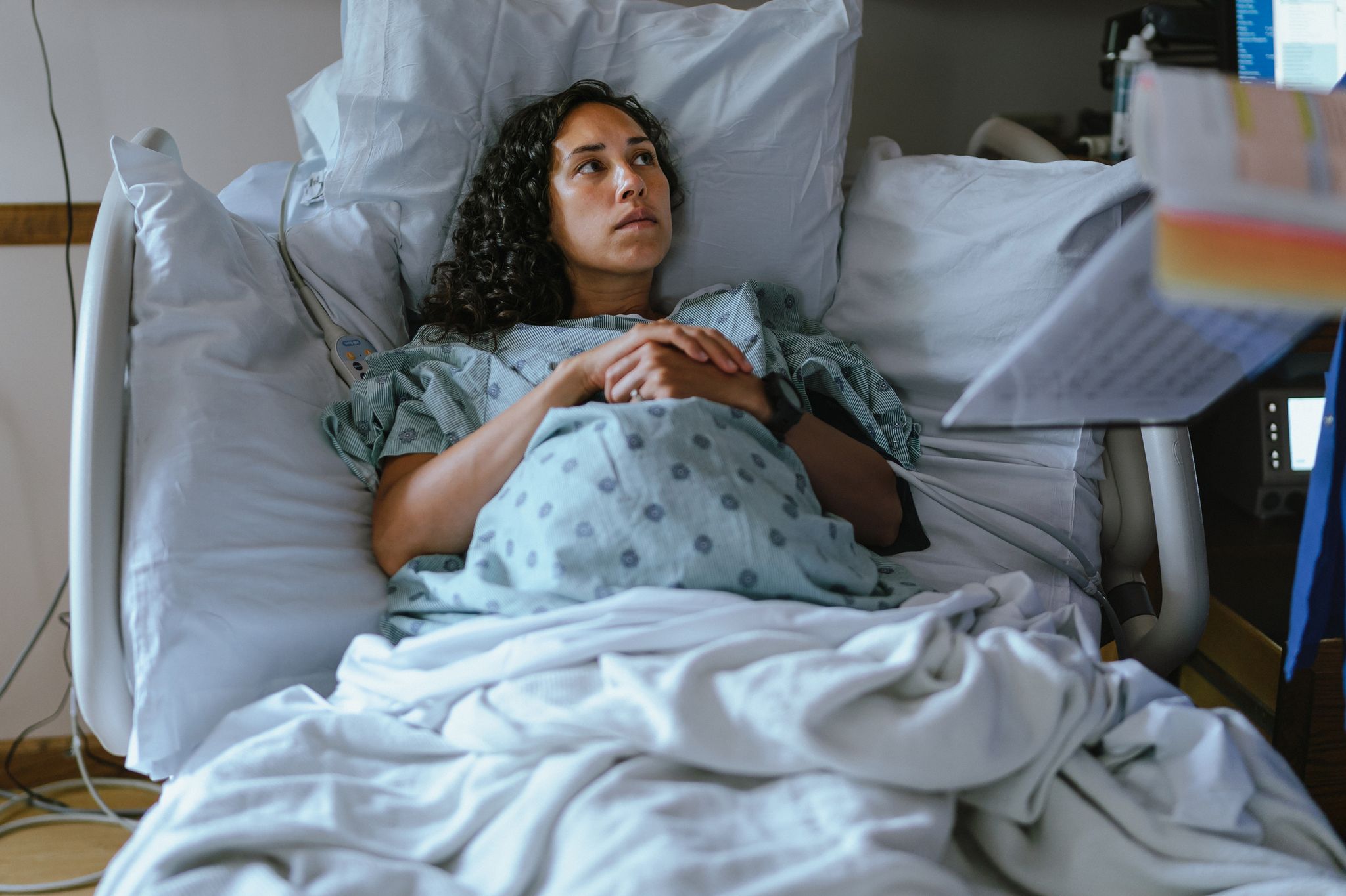 a pregnant woman lies in a hospital bed and speaks with her doctor while in labor
