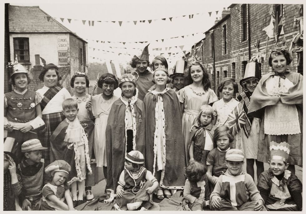 a photograph of children wearing fancy dress in flint street, cardiff, for the coronation of king george vi