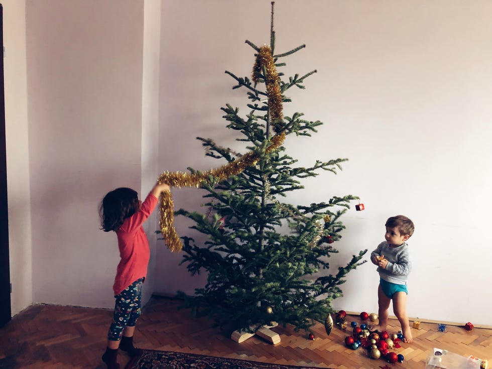 Children Decorating Christmas Tree At Home
