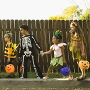 children in halloween costumes holding hands