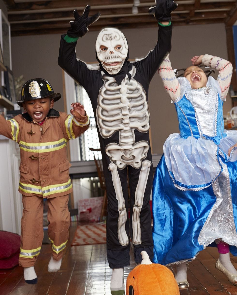 children in halloween costumes jumping for joy