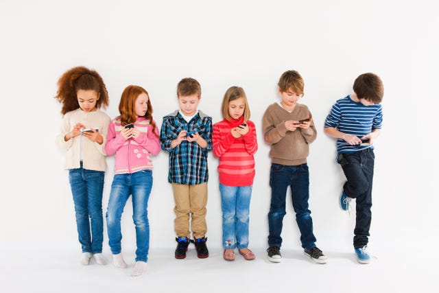 Children using smartphones, standing in a row