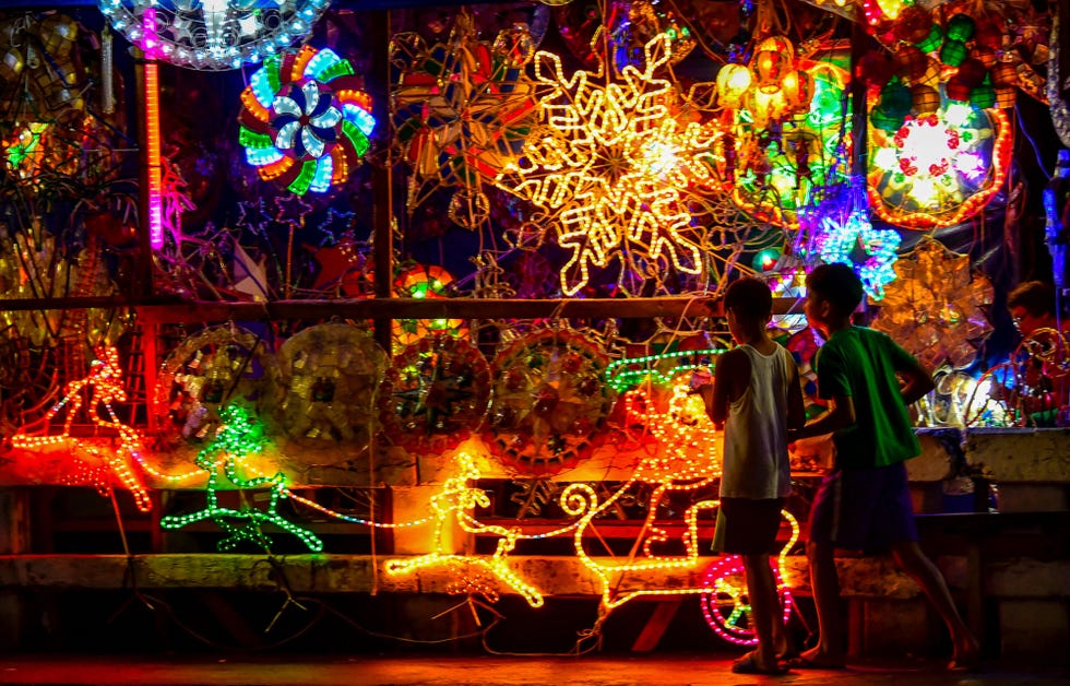 two young boys in the philippines with a light display